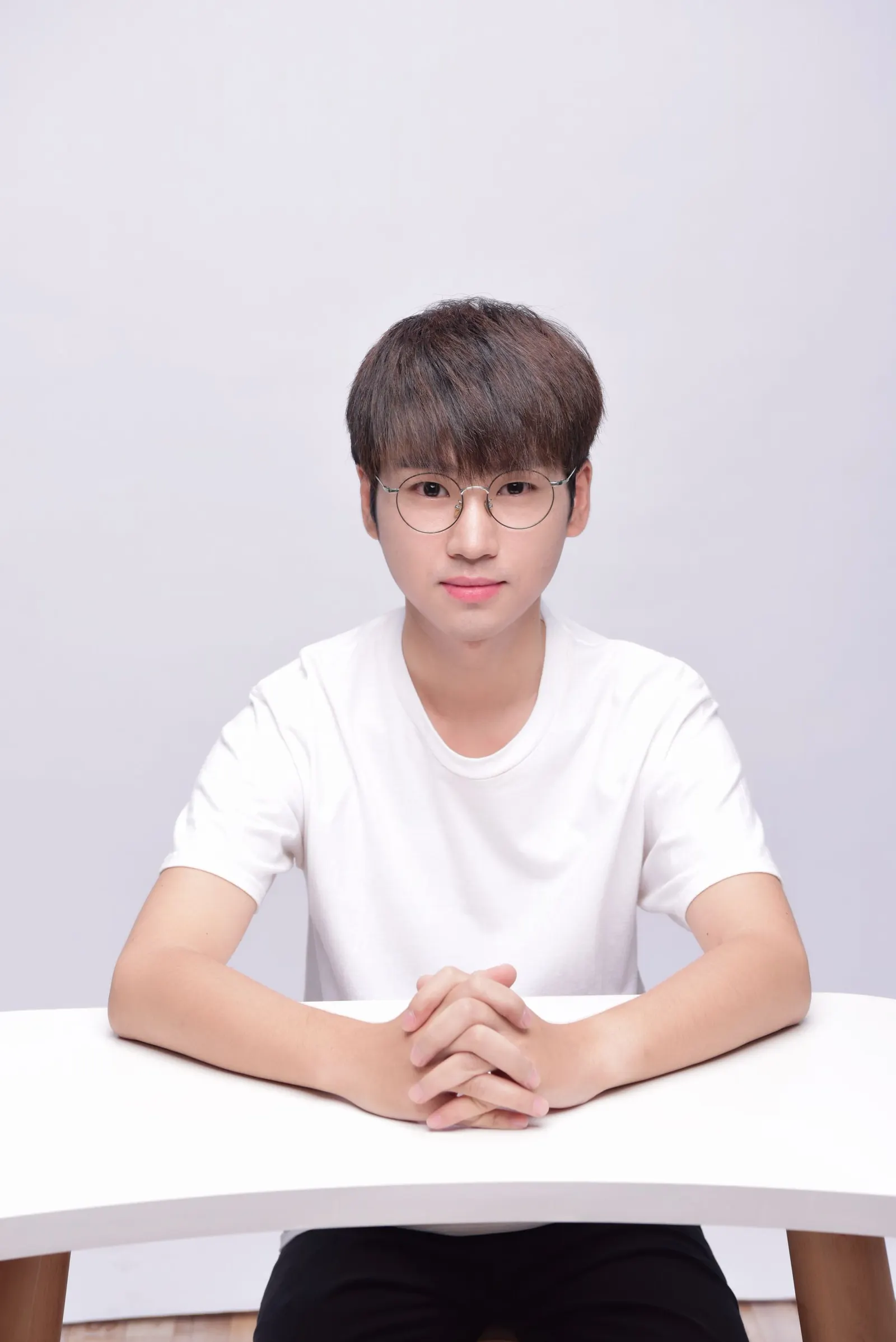 Young student wearing glasses sitting at a desk