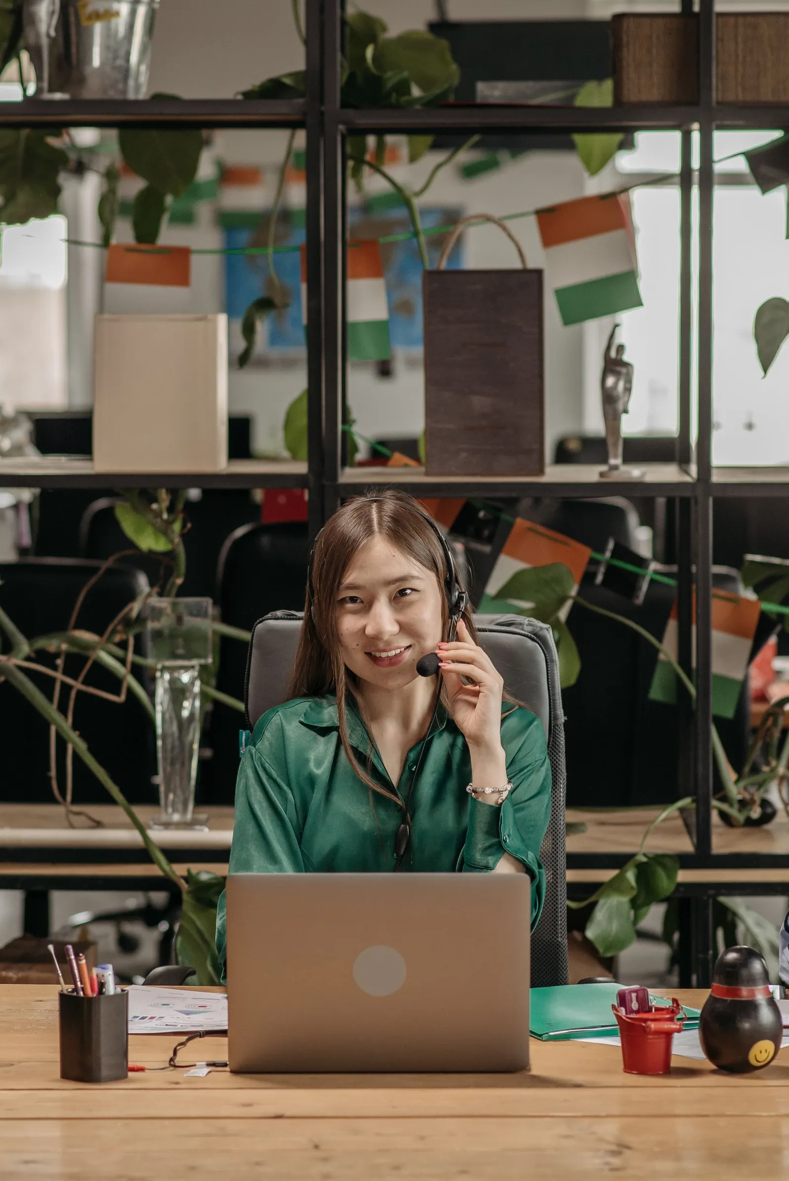 Customer service advisor with a headset answering questions at a desk